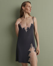 Effetto bamboo chemise spaghetti strap 03162 – women's sleepwear, smoke grey
Woman wearing a dark slip dress with lace details against a green background