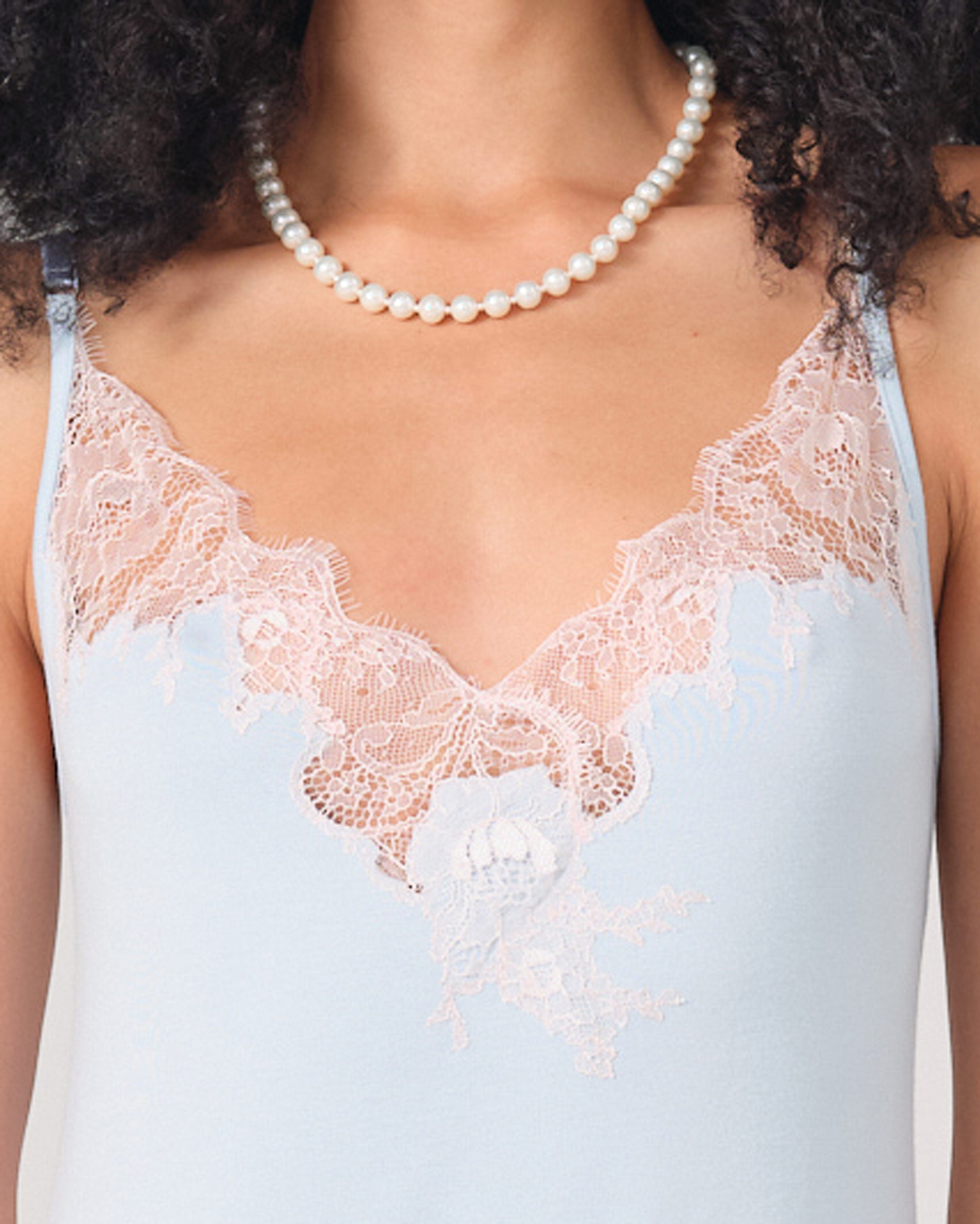 Effetto bamboo chemise spaghetti strap 03162 – women's sleepwear, icy blue
Light blue lace-trimmed top worn by a person with a pearl necklace.
