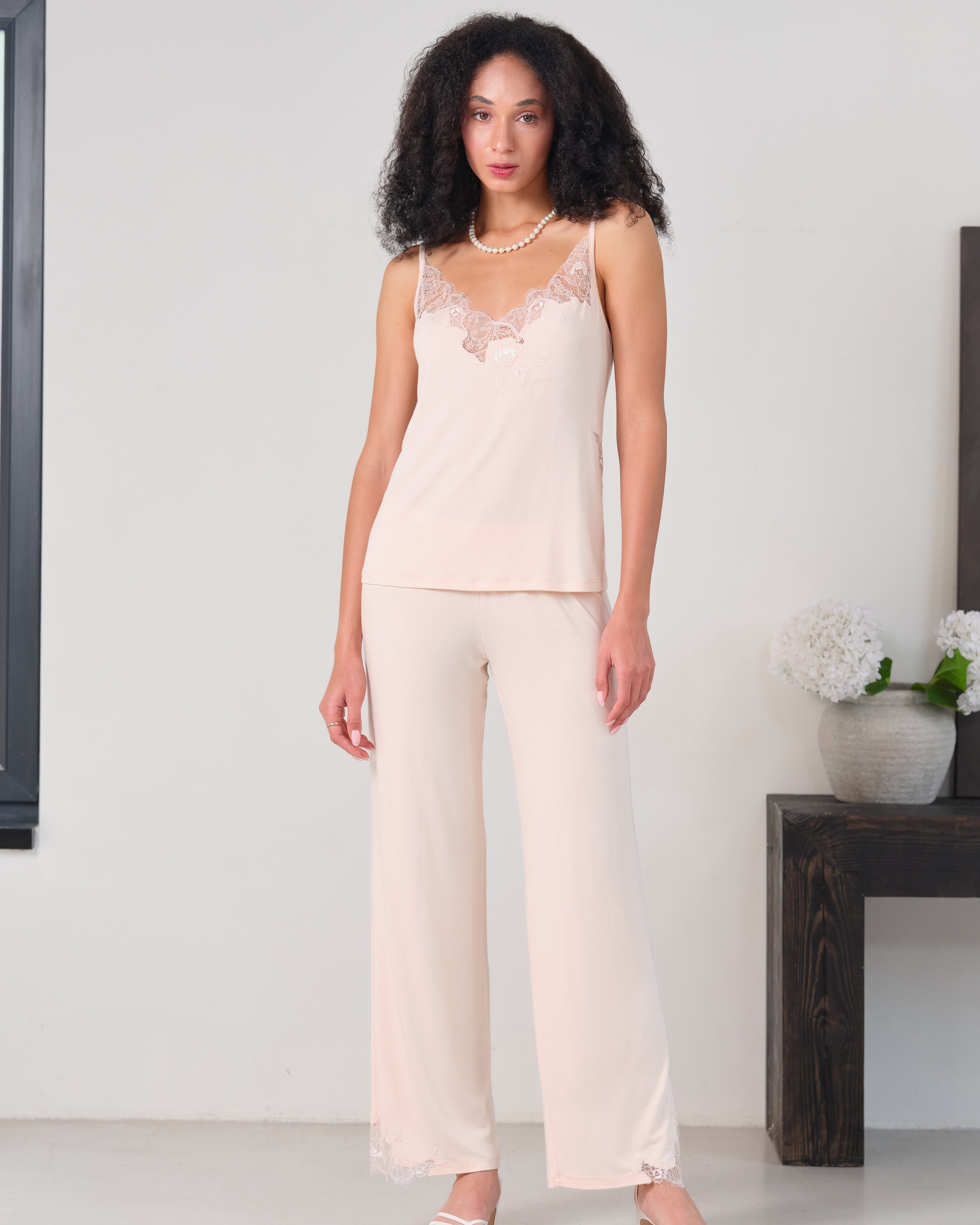 Effetto bamboo camisole pajama set 03163 – women's sleepwear, rosy peach
Woman wearing a cream lace top and pants in a minimalistic room.