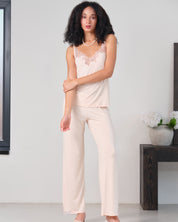 Effetto bamboo camisole pajama set 03163 – women's sleepwear, rosy peach
Woman wearing a light pink lace top and cream pants in a minimalistic room.
