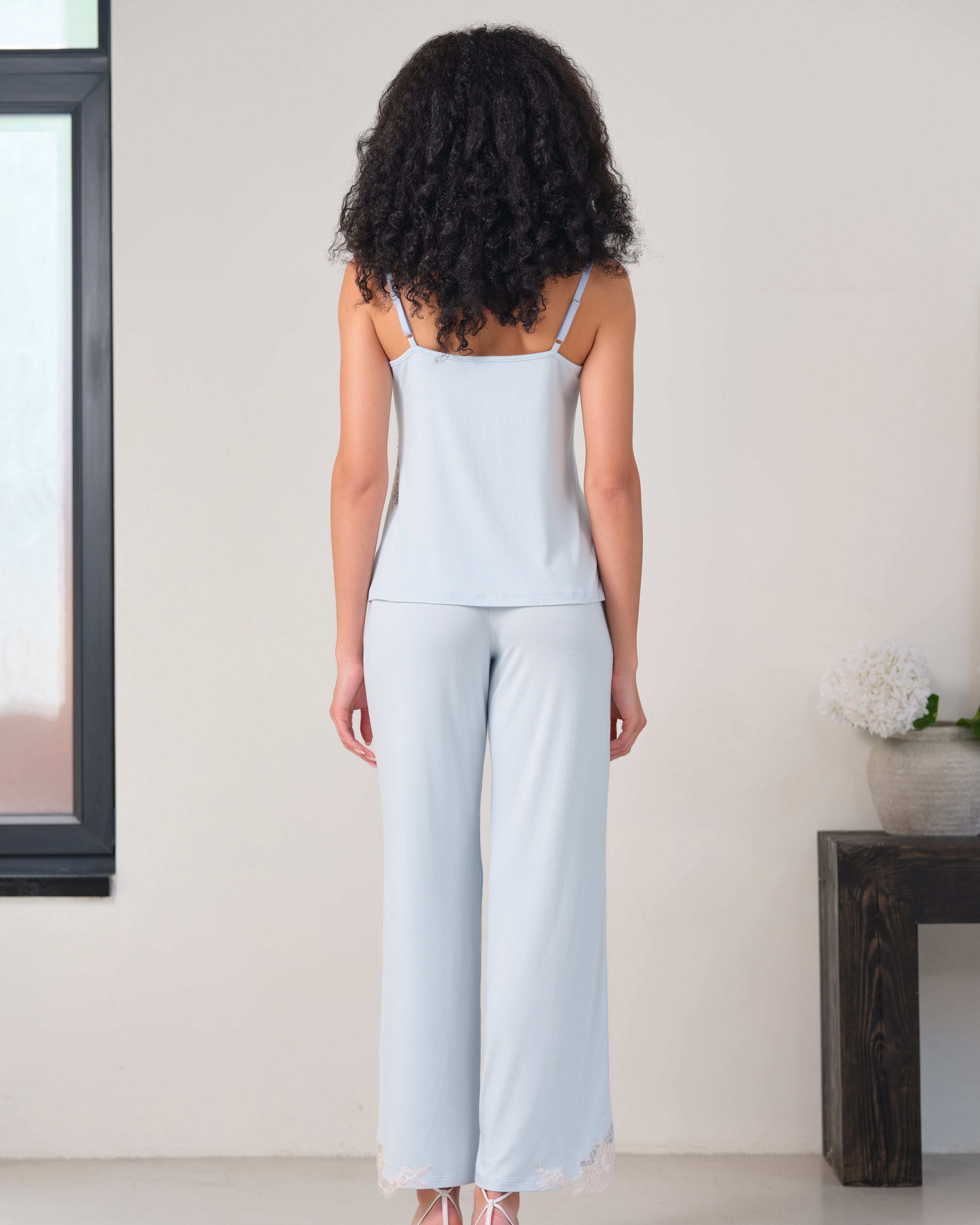 Effetto bamboo camisole pajama set 03163 – women's sleepwear, icy blue
Woman wearing a light blue sleeveless top and wide-leg pants in a minimal indoor setting.