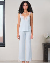 Effetto bamboo camisole pajama set 03163 – women's sleepwear, icy blue
Woman wearing a light blue lace top and wide-leg pants in a minimalistic room.