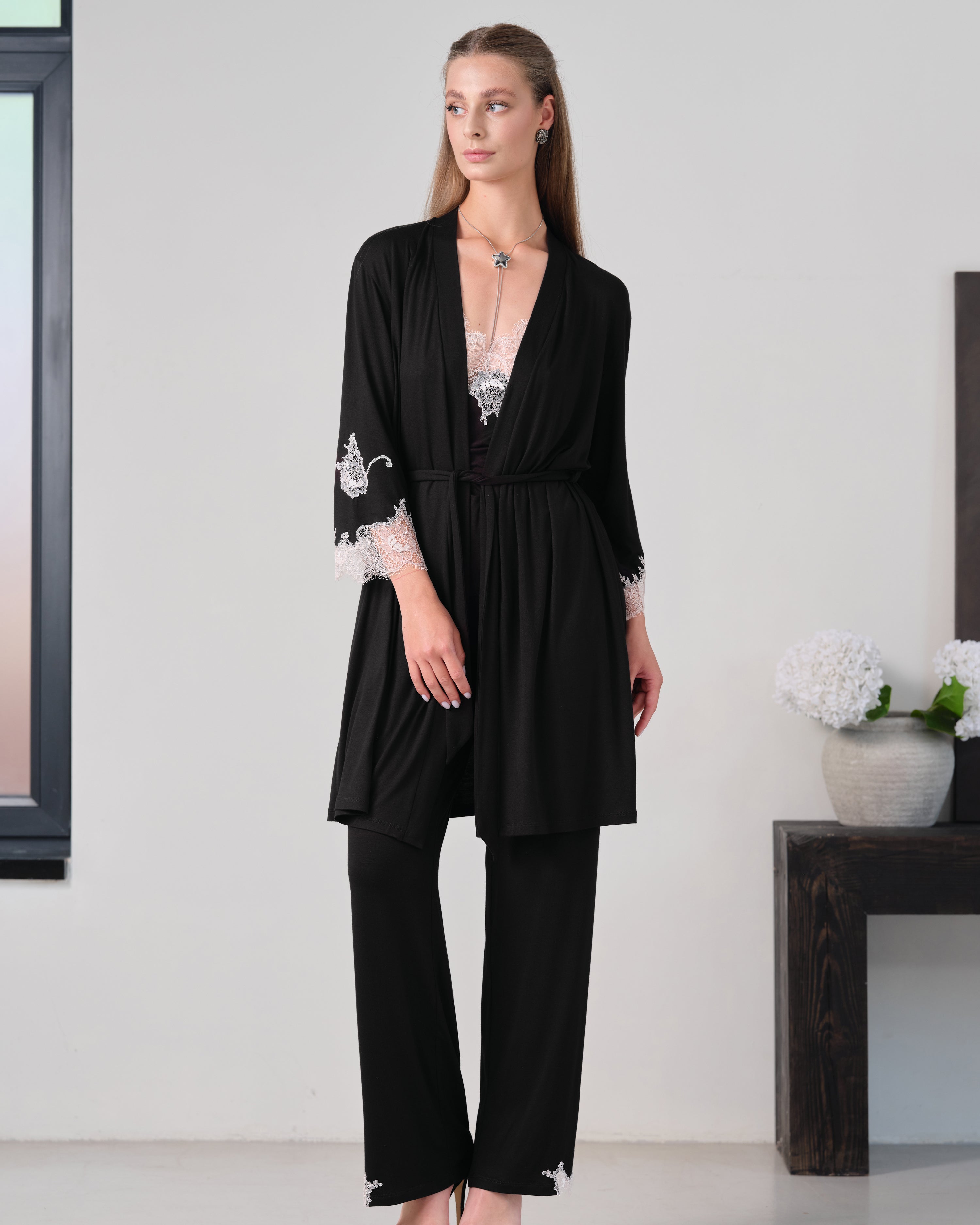 Effetto bamboo camisole pajama set 03163 – women's sleepwear, black
Woman wearing a black outfit with lace details in a minimalistic setting