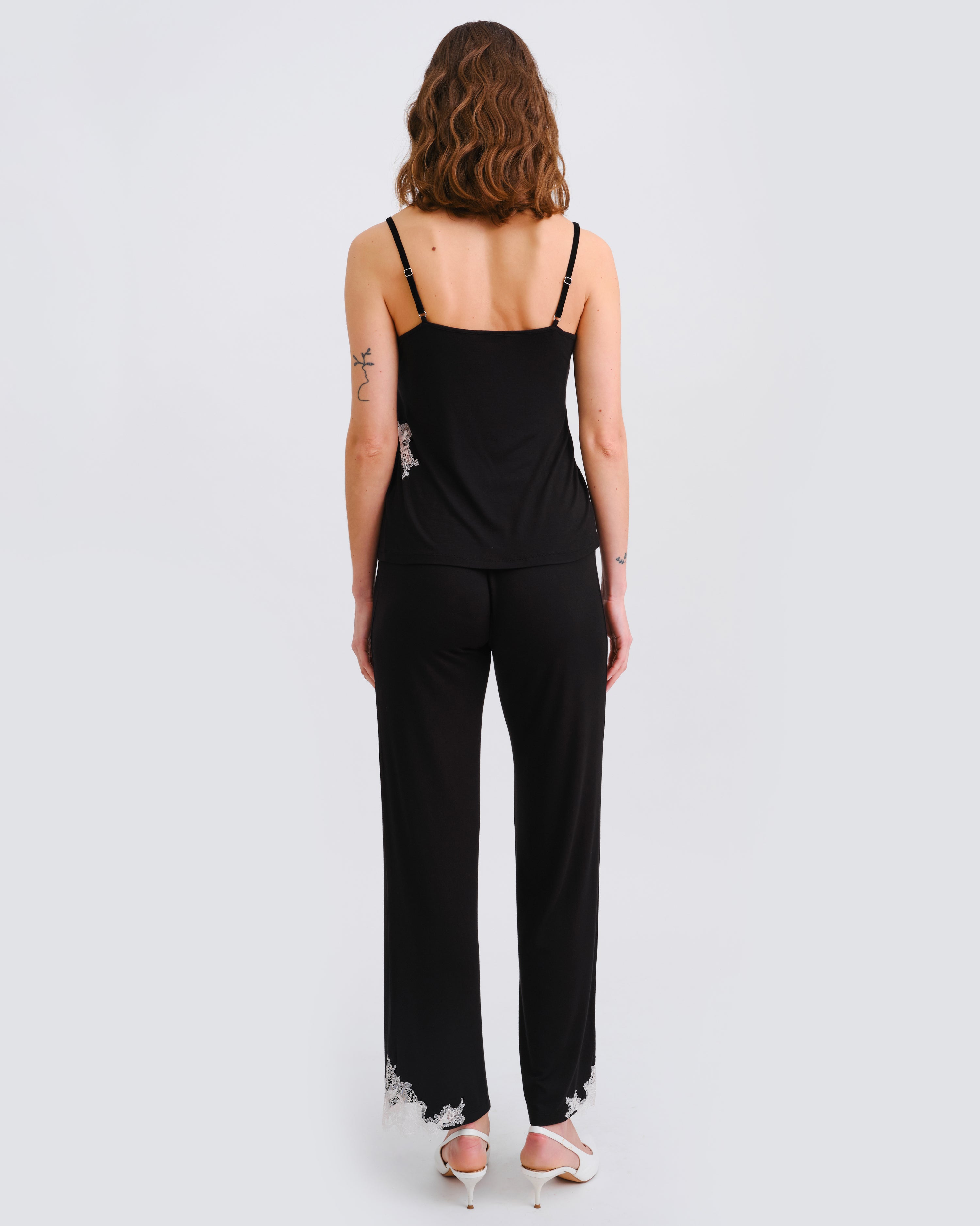 Effetto bamboo camisole pajama set 03163 – women's sleepwear, black
Woman wearing a black jumpsuit with lace details on a white background