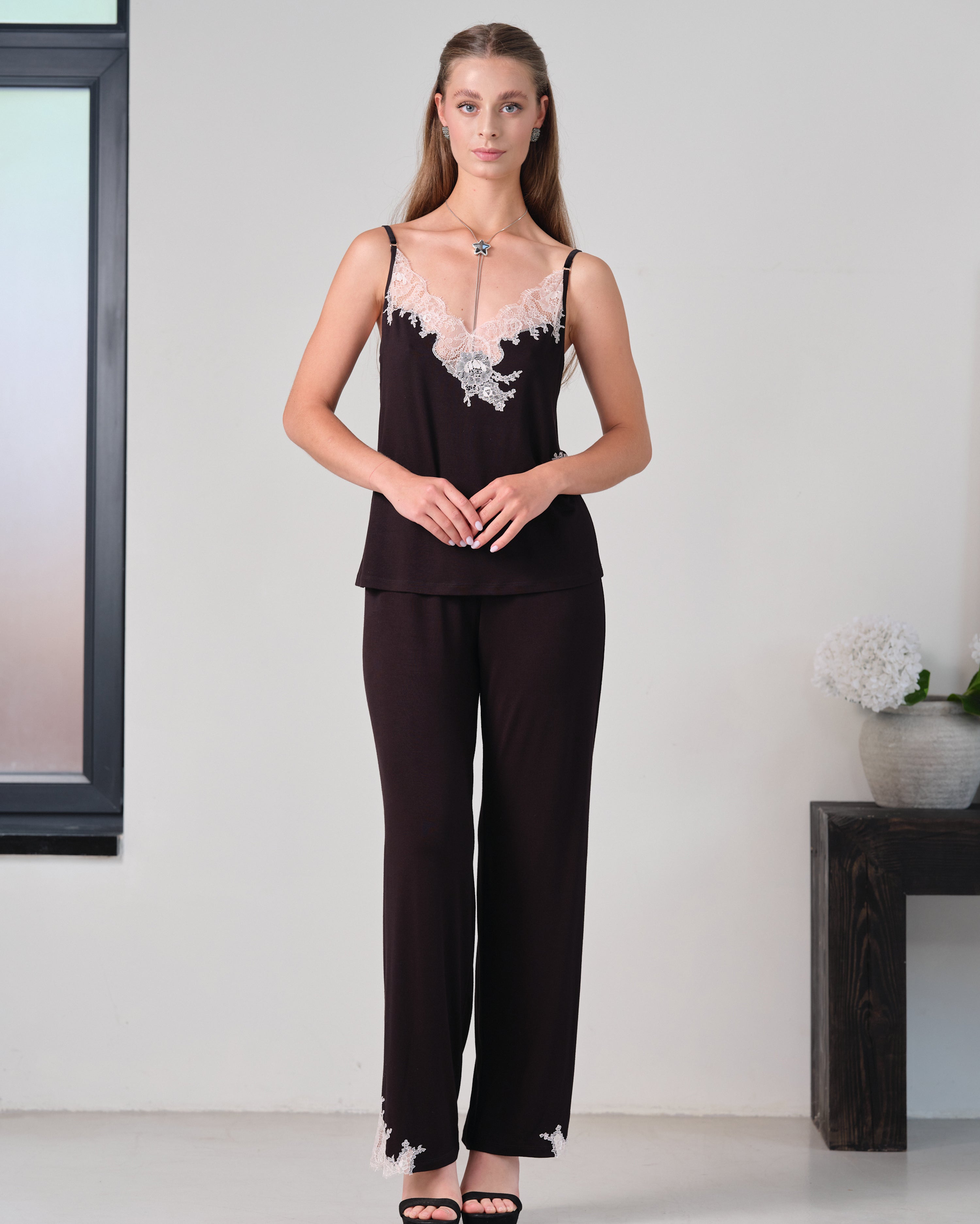 Effetto bamboo camisole pajama set 03163 – women's sleepwear, black
Woman wearing a black outfit with floral details in a minimalistic setting