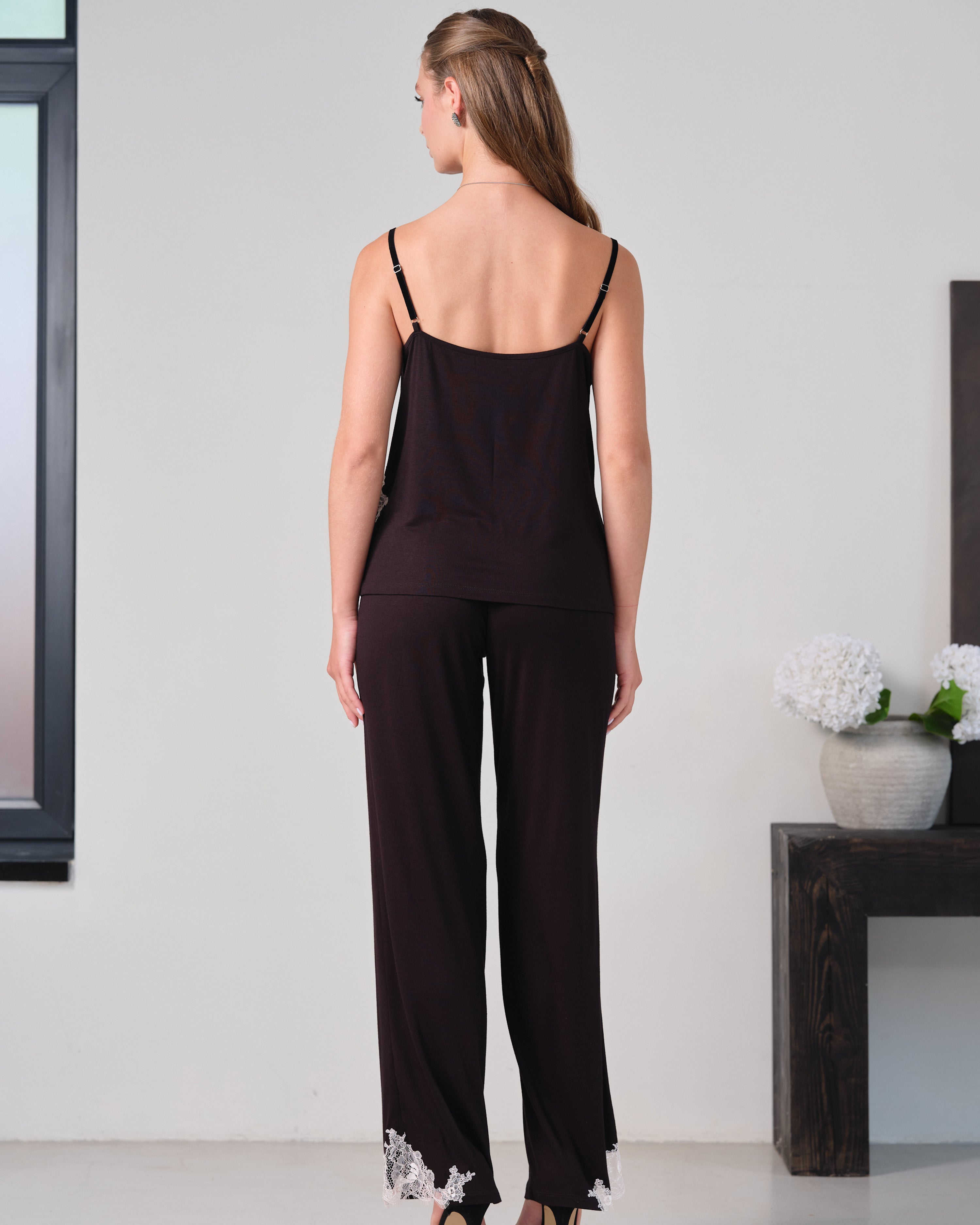 Effetto bamboo camisole pajama set 03163 – women's sleepwear, black
Woman wearing a black slip dress with floral lace trim in a minimal indoor setting.