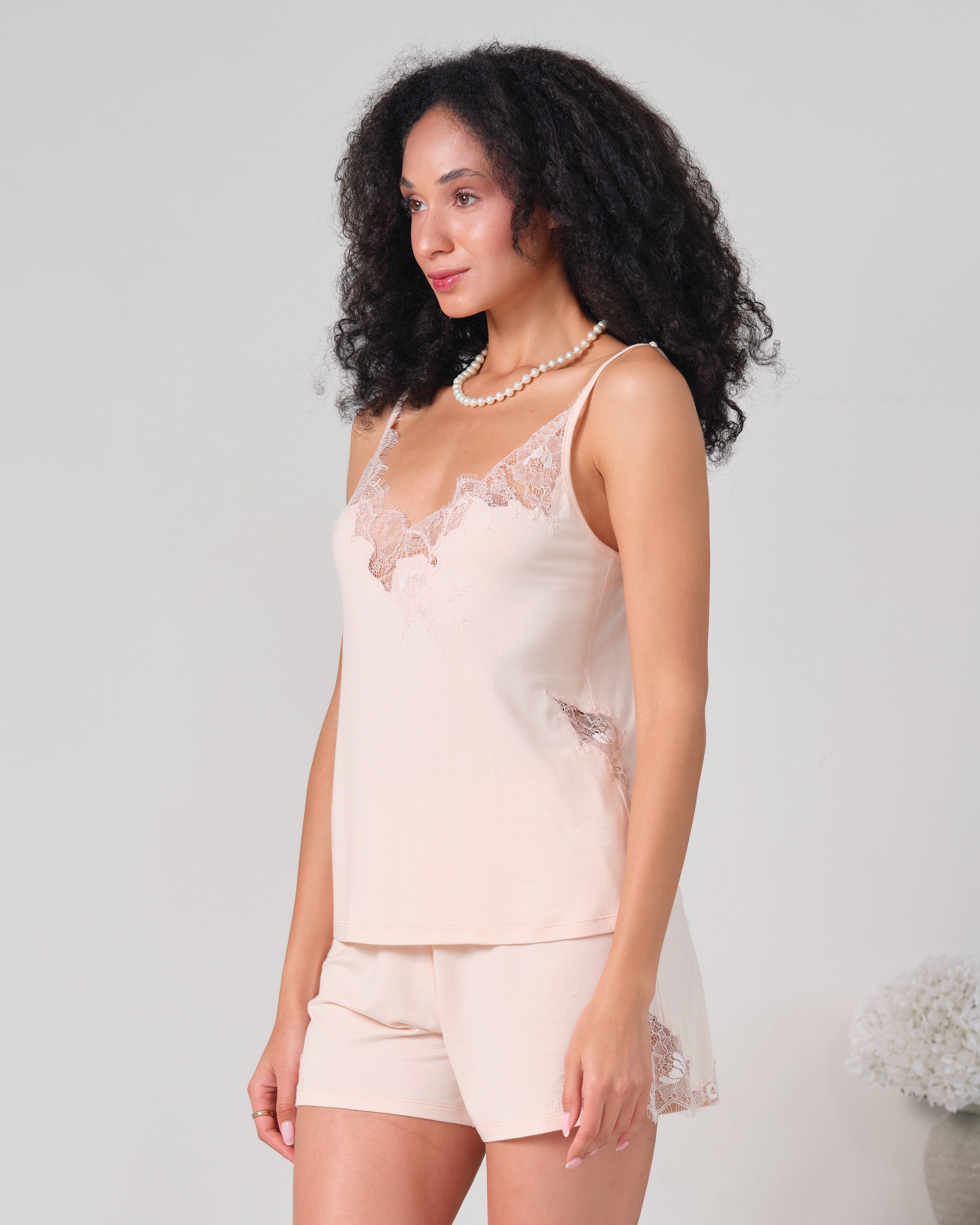 Effetto bamboo cami shorts set 03163 – women's sleepwear, rosy peach
Woman wearing a light pink lace camisole and shorts set on a plain background