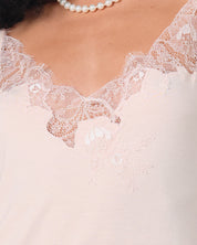 Effetto bamboo cami shorts set 03163 – women's sleepwear, rosy peach
Close-up of a lace-trimmed garment with a pearl necklace.