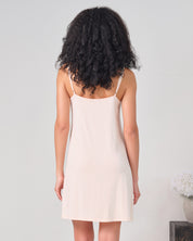 Effetto bamboo chemise spaghetti strap 03162 – women's sleepwear, rosy peach
Woman wearing a beige slip dress against a plain background