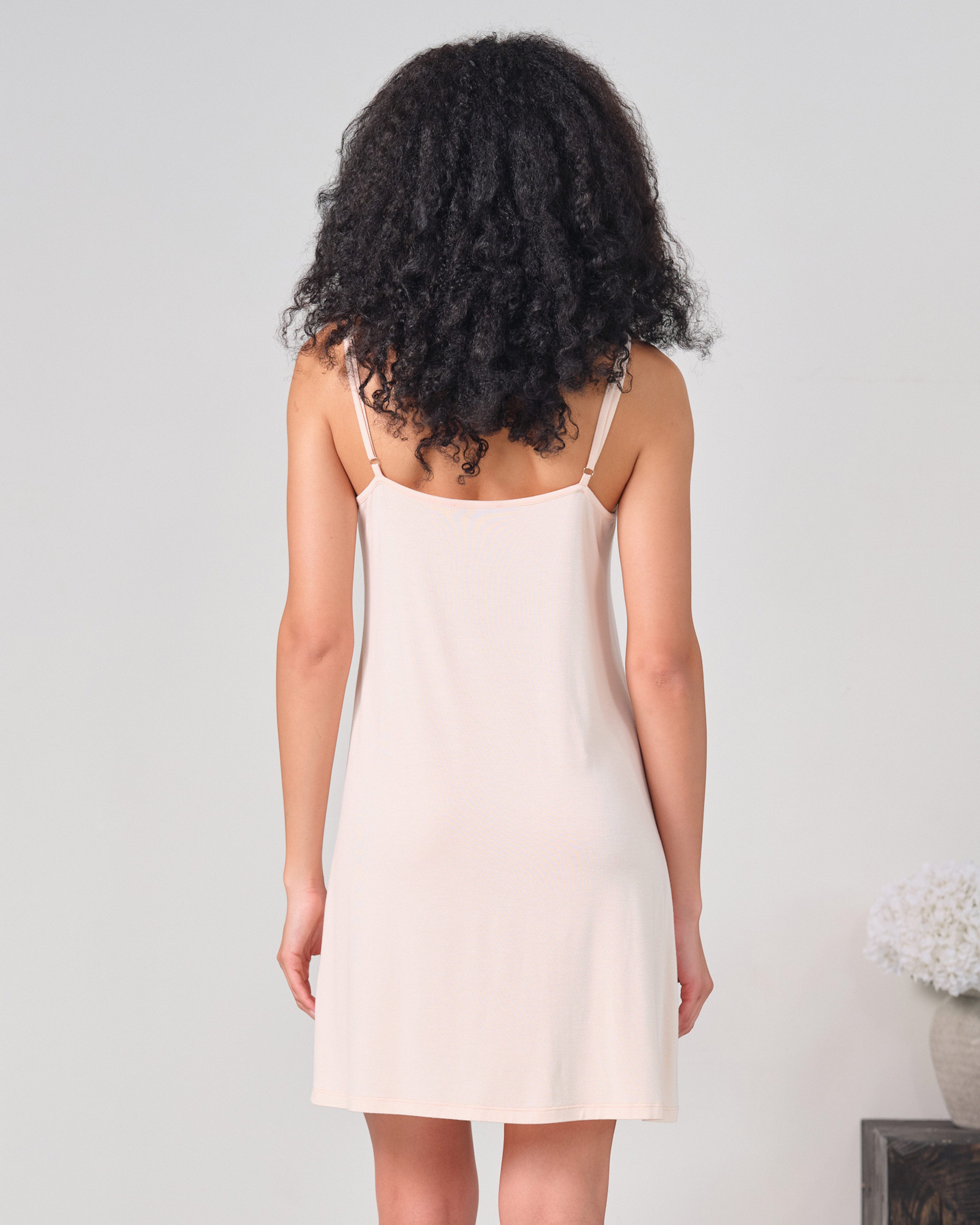 Effetto bamboo chemise spaghetti strap 03162 – women's sleepwear, rosy peach
Woman wearing a beige slip dress against a plain background
